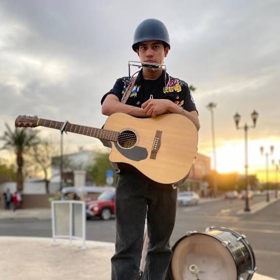 Héctor tocando guitarra al atardecer en Mexicali